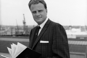 Billy Graham, the famed American evangelist, poses on board the liner Queen Mary on his arrival at Southampton, Hampshire, from New York, May 22, 1961. He is to tour Britain. (AP Photo)